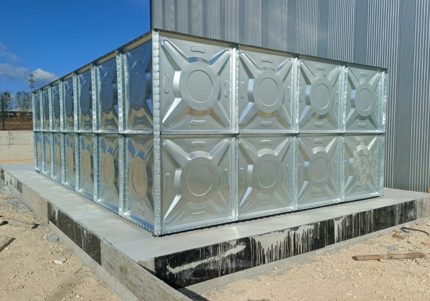 Fabrika sahasında beton kaide üzerine kurulmuş iki katlı galvaniz modüler su deposu